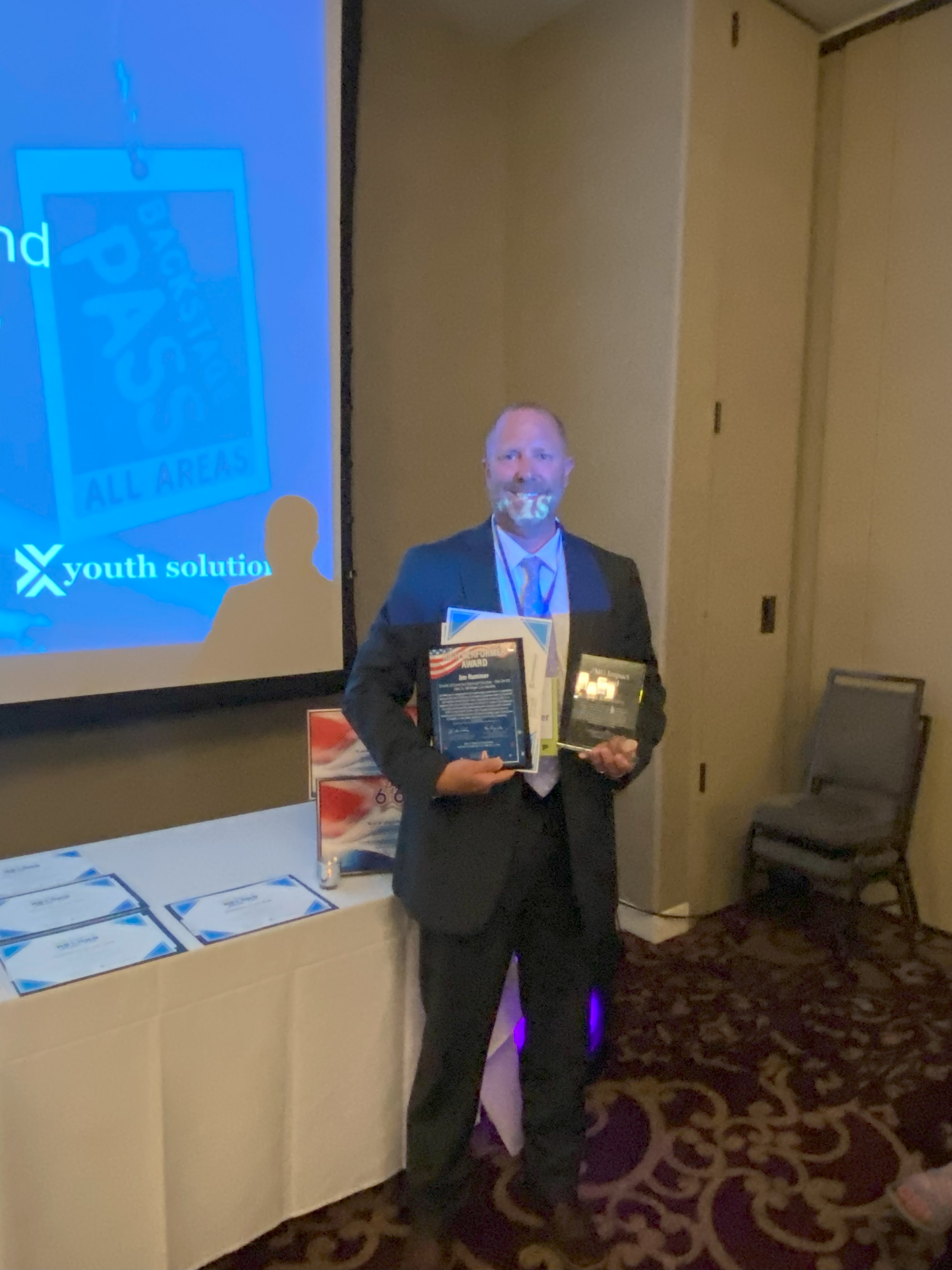 Man standing holding awards