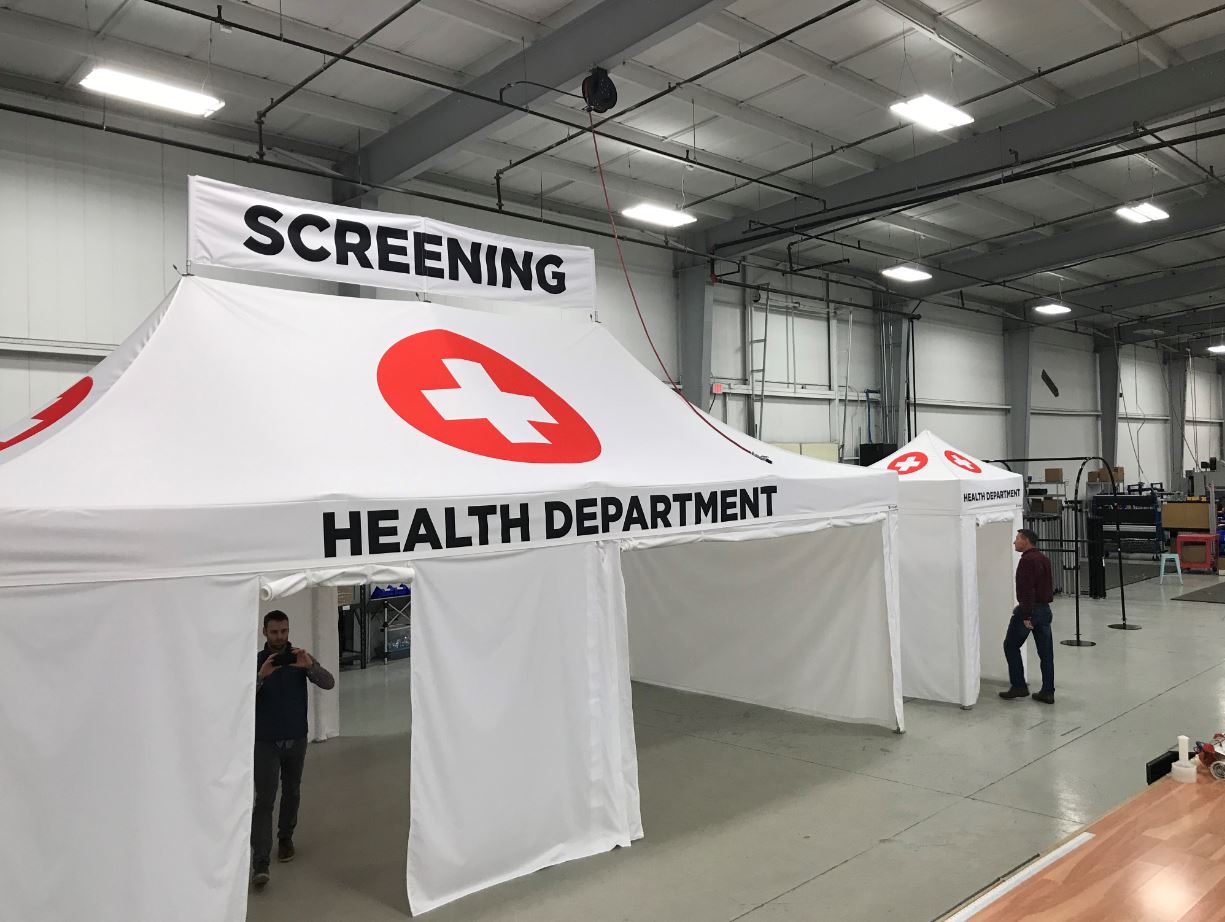 Health department screening tent inside high ceiling building